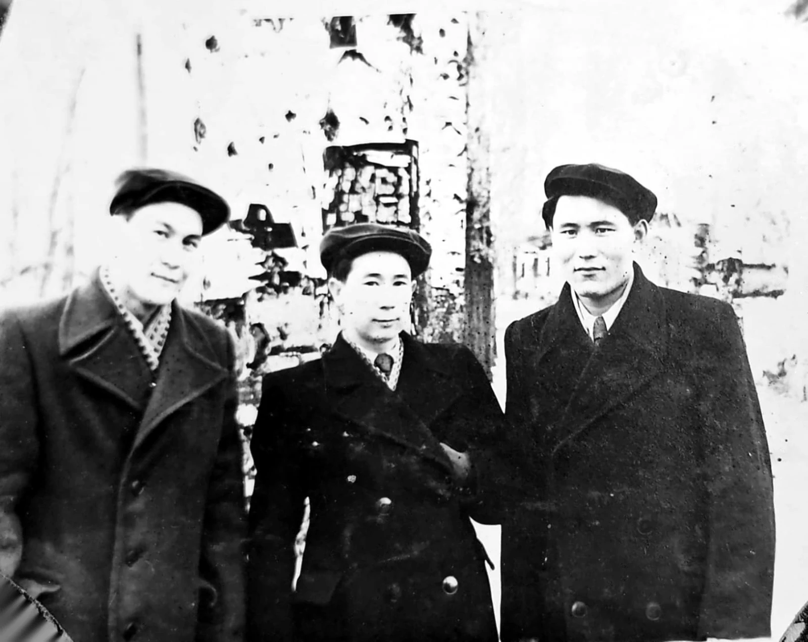 Three young men in caps and overcoats in winter